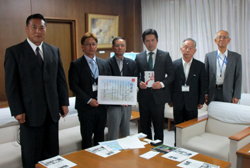 写真：株式会社ワイエス・コーポレーション会長 中尾安民氏から新庁舎建設事業に対する寄附を受領する市長