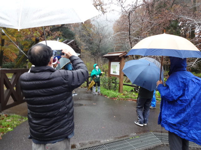 屋外で看板の説明を受けている