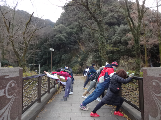 橋の欄干に手をついてストレッチしている