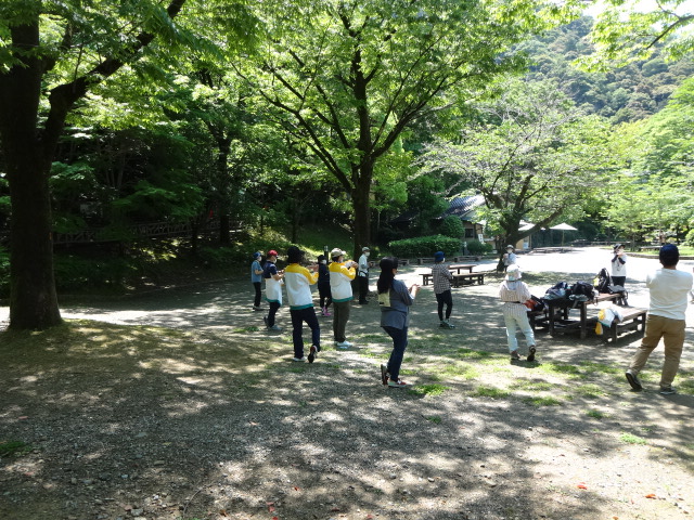 参加者が輪になって足首のストレッチをしている様子