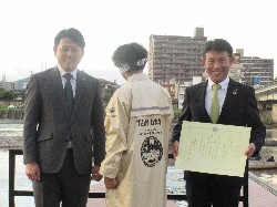 令和5年度ぎふ長良川鵜飼観覧船乗船客5万人達成記念式典にて、あいさつ及び記念品を贈呈。その後、一般社団法人岐阜ファッション産業連合会理事長 武藤昭成氏からの鵜飼観覧船船員用の雨合羽の寄附に対し、感謝状を贈呈の様子