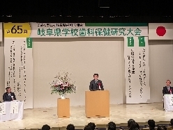 第65回岐阜県学校歯科保健研究大会に出席し、あいさつの様子