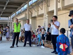 夏休みに学校で遊ぼう！～明郷小PTAサマーイベント～に出席し、あいさつ（明郷小学校）の様子