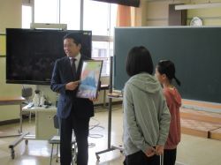 白山小学校の生徒達に対し姉妹校であるウィーン市デッカーガッセ小学校の生徒達から預かった作品を贈呈（白山小学校）の様子
