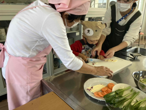 写真：子どもが野菜を切っているのを見守っている様子