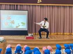 黒野こども園「くろのdeマルシェ」に出席し、子どもたちに絵本の読み聞かせする様子