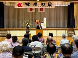 梅林地区敬老会に出席し、あいさつ(梅林小学校)