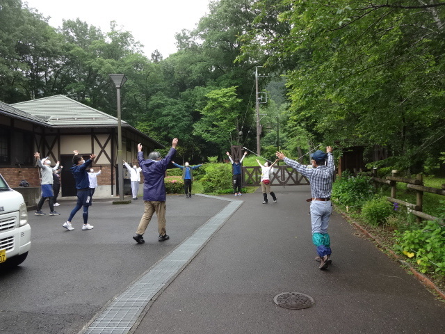 参加者が屋外で腕を伸ばしてストレッチをしている様子