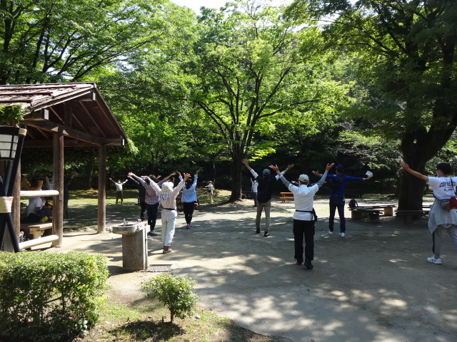 参加者が両腕を伸ばしてストレッチを行っている様子