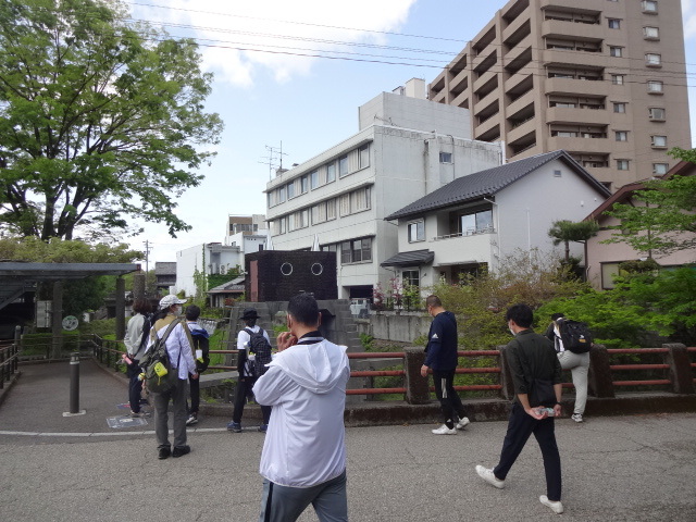 形が特徴的な水門を参加者が見ている様子