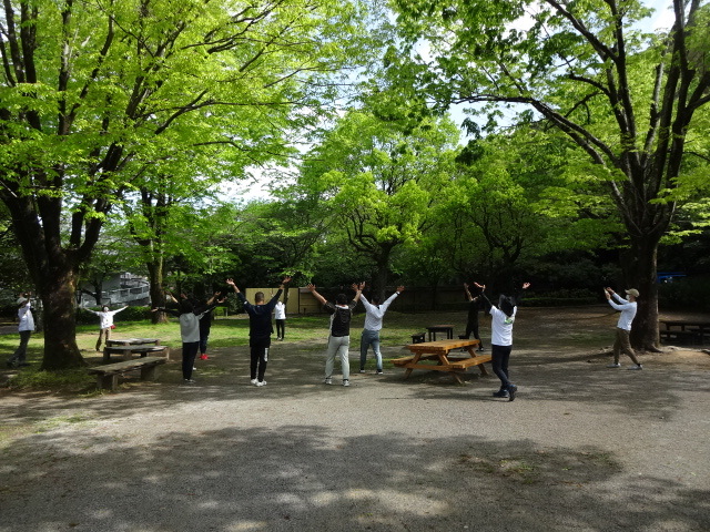 参加者が輪になってストレッチしている様子