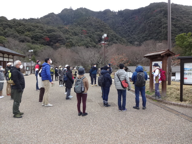 屋外の看板前で参加者が説明を受けている