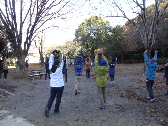 参加者が輪になってストレッチしている